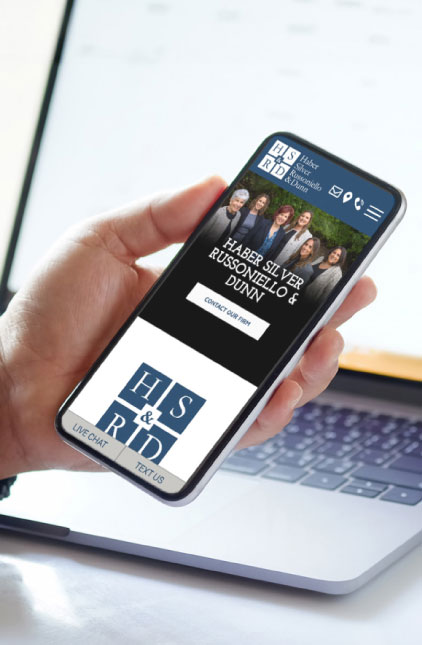 A person holds a smartphone displaying a law firm's website, 