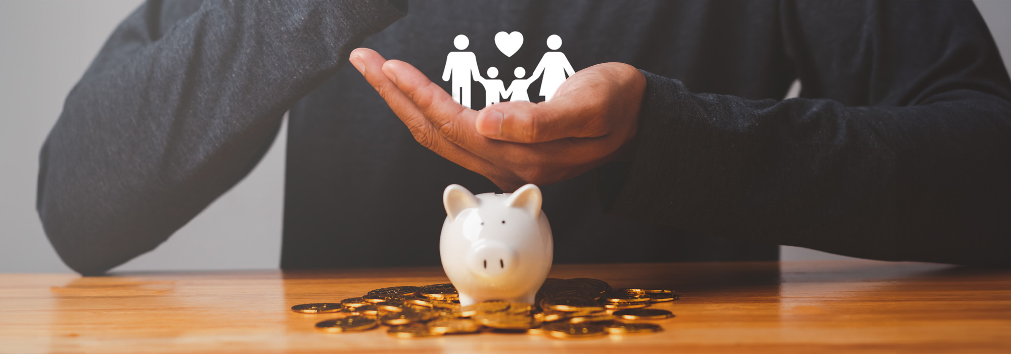 businessman with coin piggy bank hold key house and icon family on table