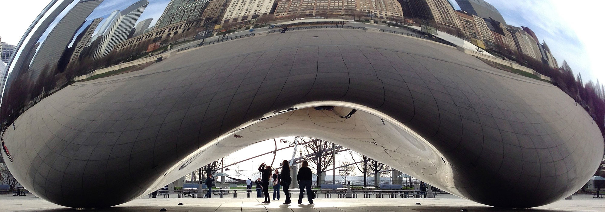 People standing underneath the reflective surface of 