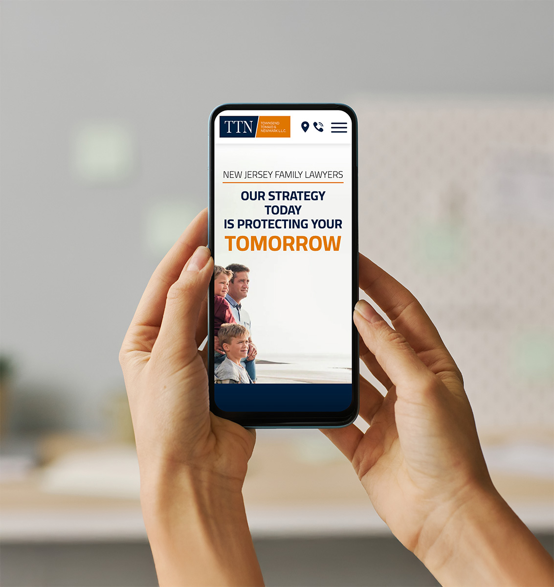 A person holds a smartphone displaying a law firm's website. The screen reads,